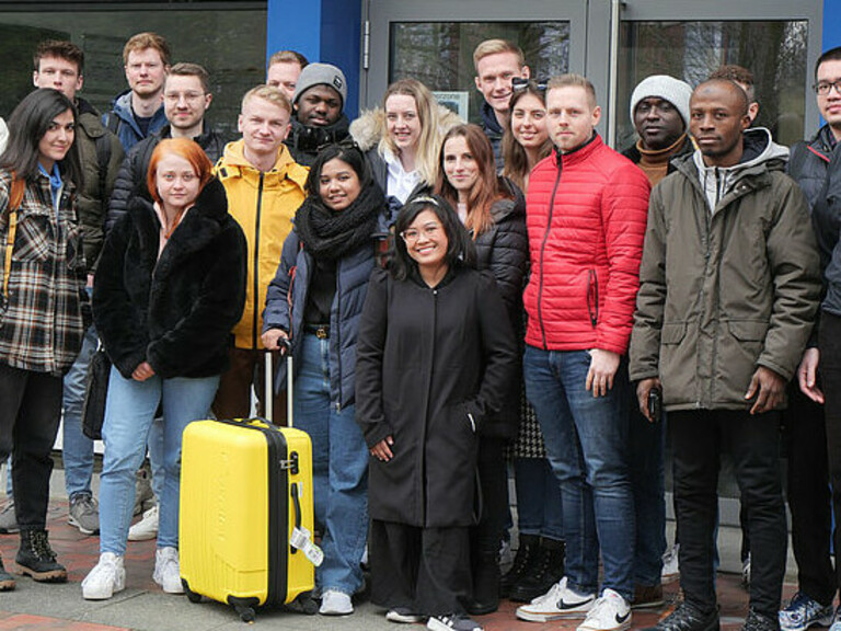 Studierende der Jade Hochschule und der Partnerhochschulen aus Finnland, der Slowakei und den Niederlanden zusammen mit Projektleiter Prof. Dr. Hardy Oepping (re.) vor dem Westgebäude am Campus Wilhelmshaven. (Foto: Daniela Wrage/Jade HS)