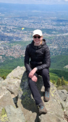 Lorena sitzt auf einem Berg, im Hintergrund die Stadt Sofia