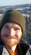 Wolfgang auf einer Aussichtsplattform über einem verschneiten Wald