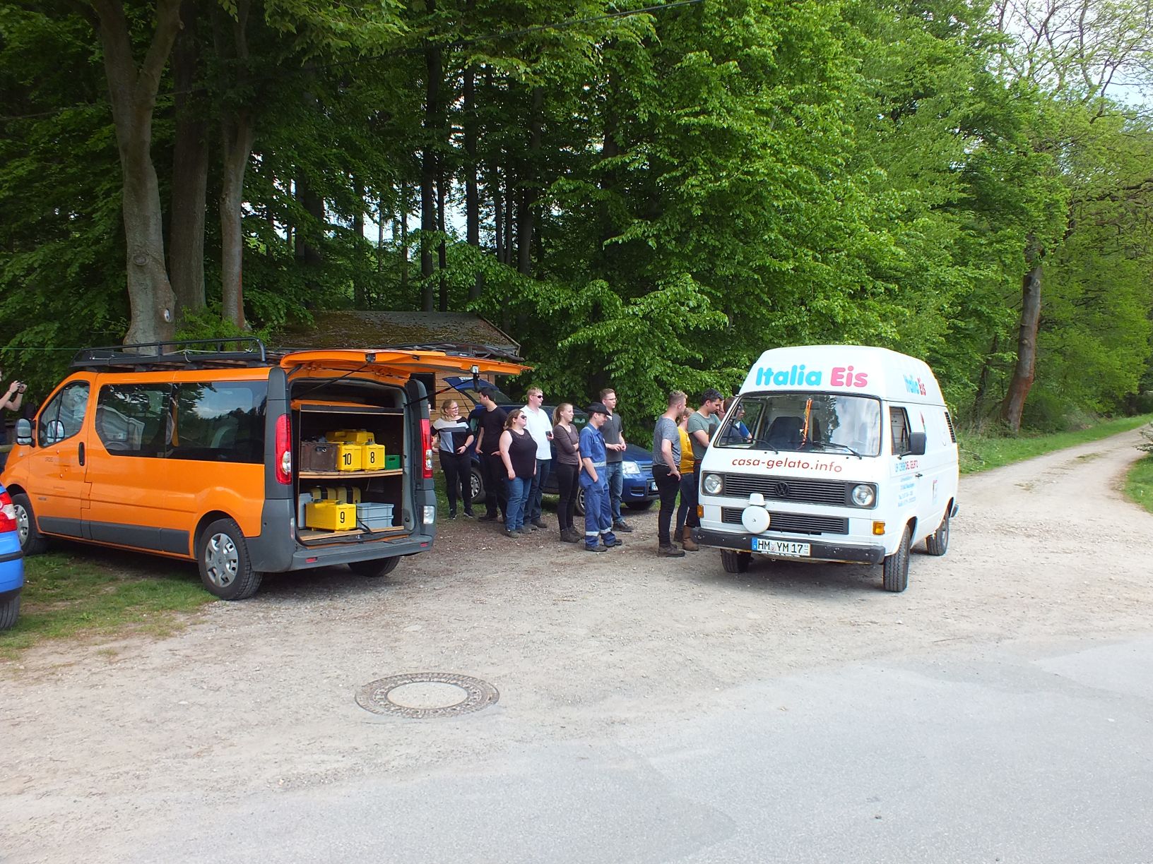 Ein Eiswagen hält am Rand des Waldes uns viele Personen stehen in der Schlange