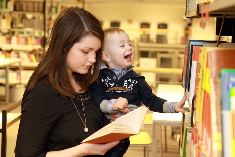 Studentin mit Kind in der Bibliothek